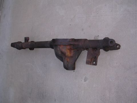 1999 Toyota Tacoma - A heavily rusted differential axle housing is shown against a concrete background.