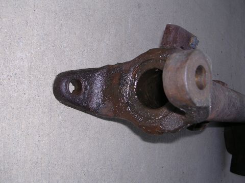 1999 Toyota Tacoma - A heavily rusted metal automotive component is shown against a textured concrete surface.