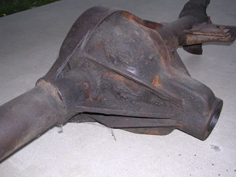1999 Toyota Tacoma - A heavily rusted differential housing rests on a concrete surface, showing signs of age and wear.