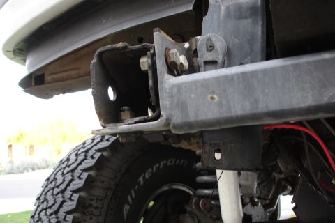 1996 Ford Bronco - The rear bumper bracket and tire are visible in this close-up shot of a vehicle's undercarriage.