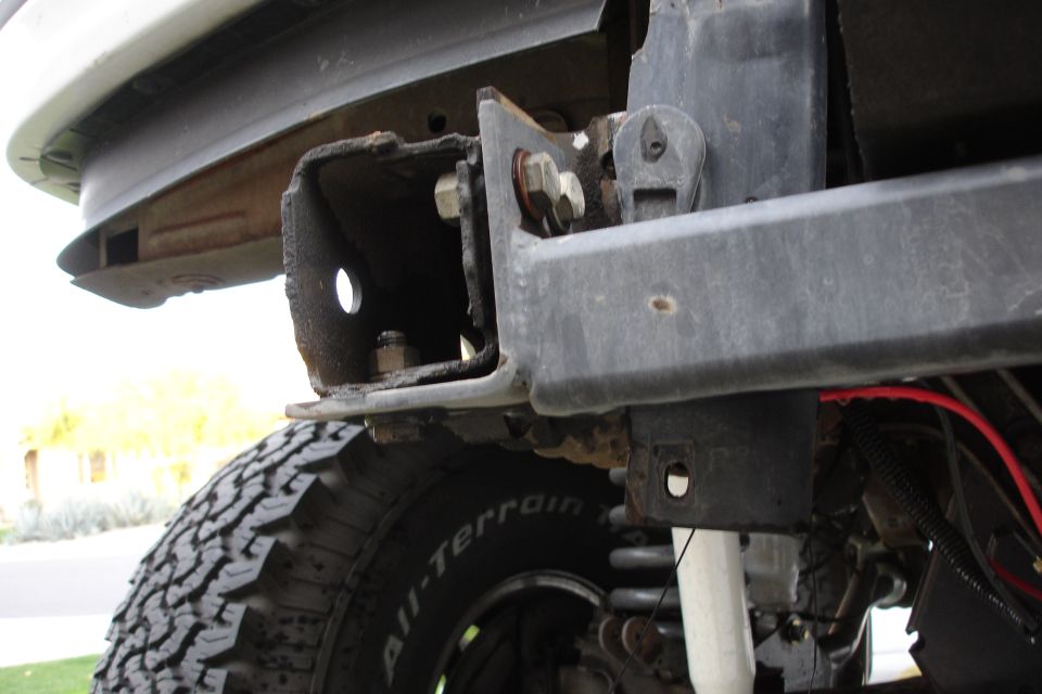 close-up of rusty bumper bracket and tire on a vehicle