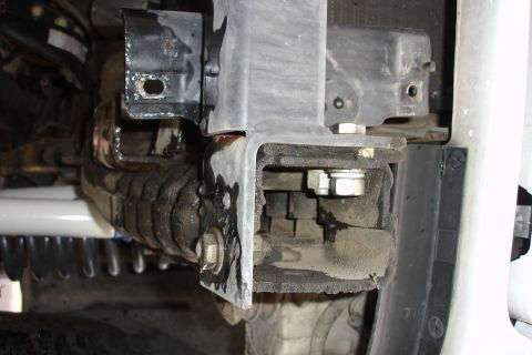 1996 Ford Bronco - Close-up view of a vehicle's bumper bracket, showing mounting hardware and protective bellows.