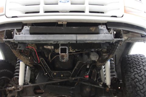 1996 Ford Bronco - Undercarriage view of a 1996 Ford Bronco, showing the front suspension and hitch.