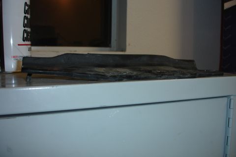 1996 Ford Bronco - A black rubber trim piece is shown resting on a shelf next to a can of cleaner.