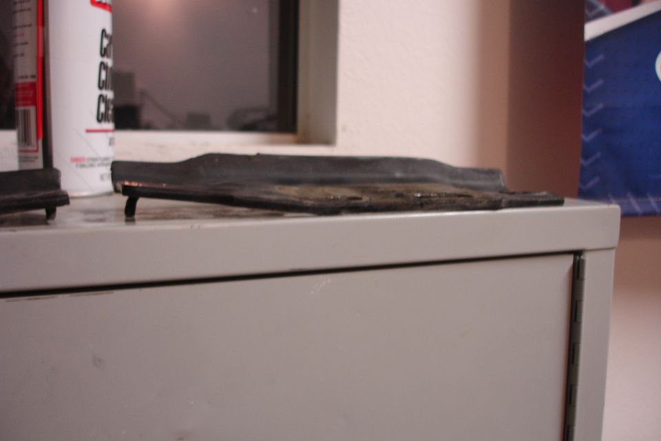 Black rubber trim piece on a light gray surface