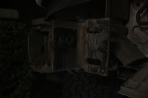 1996 Ford Bronco - Close-up of a heavily rusted metal bracket with multiple mounting holes.