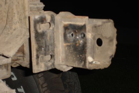 1996 Ford Bronco - A close-up view of a damaged metal bracket on a vehicle's undercarriage.