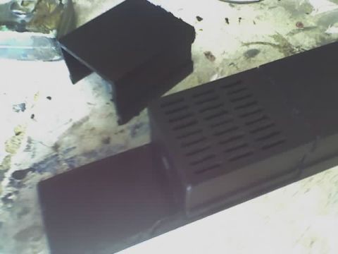 1993 Ford C-350 (Centurion Conversions) - A black plastic component with a vented surface and an additional angled piece is shown.