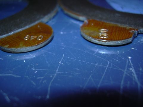 1996 Ford Crown Victoria - Two parts with stamped numbers are shown on a blue surface.