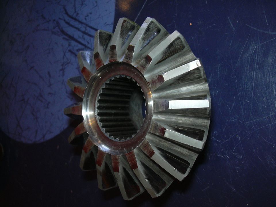 Close-up of a differential gear with many teeth. It has a splined center hole
