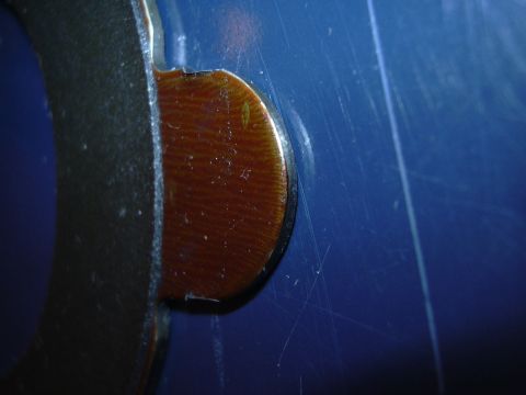 1996 Ford Crown Victoria - Detail of a brake pad showing wear material on its metal backing plate, with a blue surface in the background.