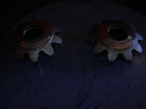 1996 Ford Crown Victoria - Close-up view of two metal gears, likely automotive parts, against a dark background.