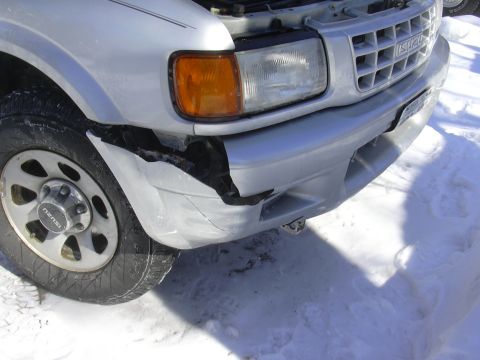 1996 Ford Crown Victoria - The front end of an Isuzu Rodeo shows significant damage to the bumper and fender area.