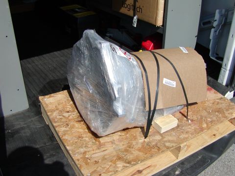 1989 Ford Bronco - A transmission, wrapped for shipping, sits on a wooden pallet inside a vehicle.