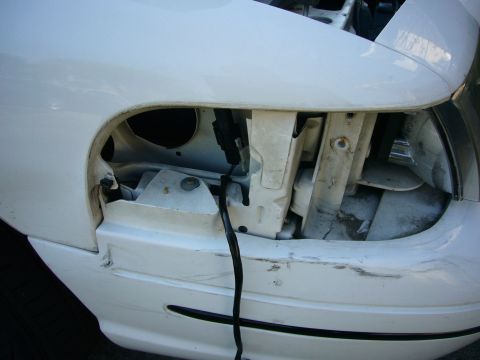 2000 Ford Crown Victoria - Front fender and headlight assembly of a white vehicle, showing internal structure and wiring.