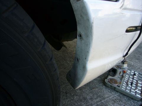 2000 Ford Crown Victoria - Detail of a car's fender and tire, with a tool organizer nearby.
