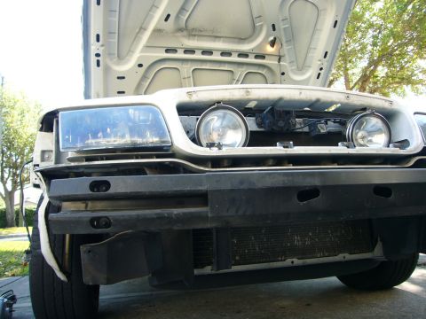 2000 Ford Crown Victoria - Front view of a white Ford Crown Victoria with its hood open, revealing the engine compartment and a push bumper.
