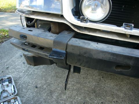 2000 Ford Crown Victoria - Installing a Go Rhino push bumper on a vehicle front end. Tools are laid out on the ground.