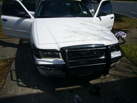 2000 Ford Crown Victoria - A white Ford Crown Victoria is shown from the front with its doors open and a push bumper installed.
