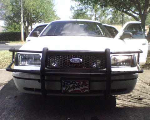 2000 Ford Crown Victoria - Head-on front view of a white Ford Crown Victoria sedan parked on a driveway with a black tubular police-style push bar/grille guard mounte…
