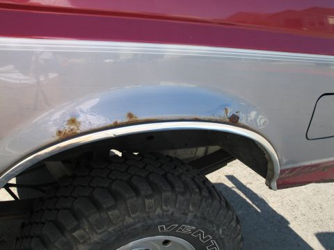 1995 Ford Bronco - Rust is visible on the fender trim and body of this 1995 Ford Bronco's rear wheel well.