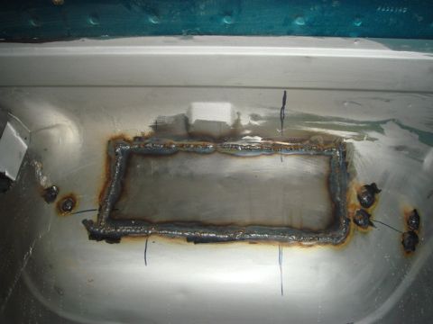1996 Ford Bronco - A freshly welded patch covers rust damage on the vehicle's floor, indicating repair work.