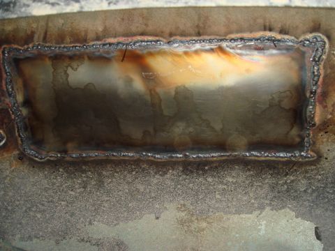 1996 Ford Bronco - Close-up of a welded metal patch, likely a repair on a vehicle's floor pan.