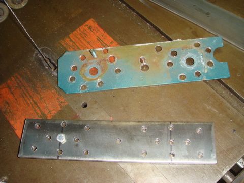 1996 Ford Bronco - Two metal plates with multiple holes are shown on a workbench, one with rust and a bolt, the other clean with a bolt and markings.