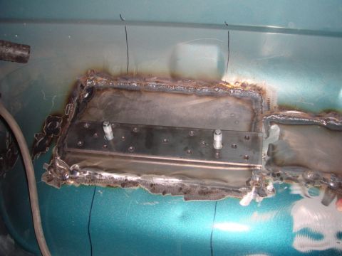 1996 Ford Bronco - Metal patch welded onto the floor of a teal vehicle, likely for rust repair.