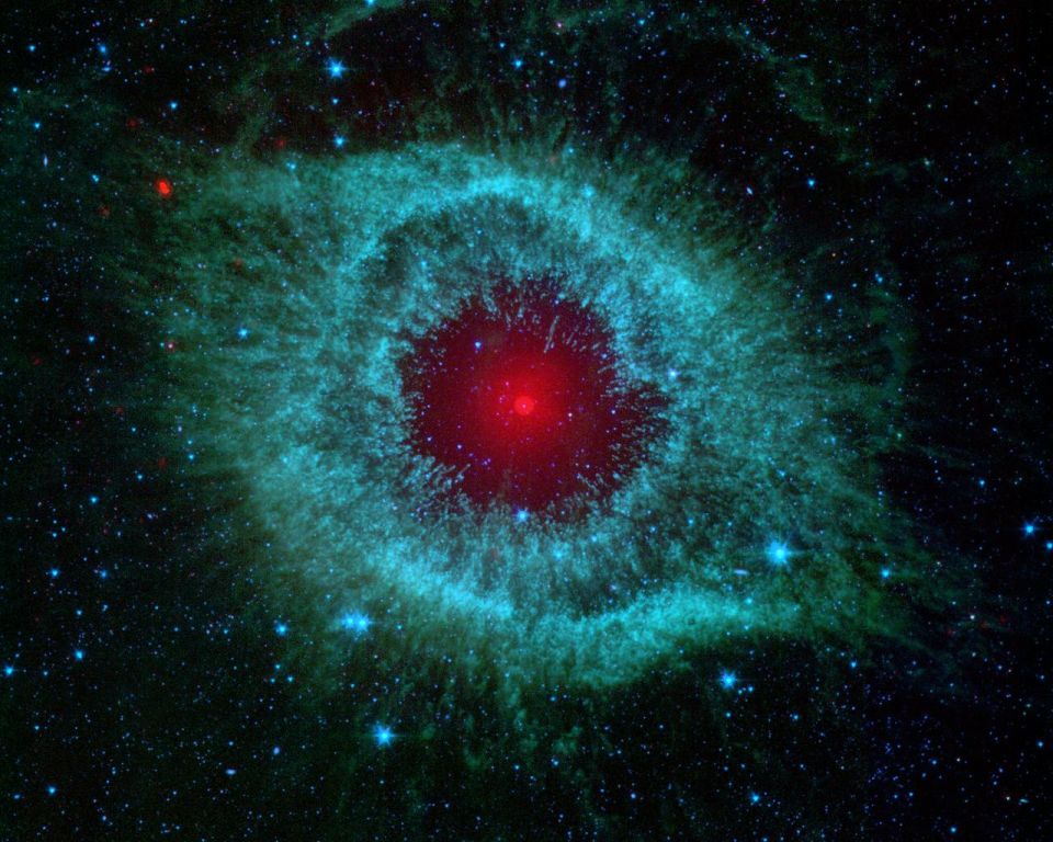 Helix Nebula with red center and teal outer rings among stars