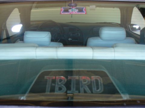 1995 Ford Thunderbird - View from the back seat shows the dashboard and a 'TBIRD' emblem on the rear window.