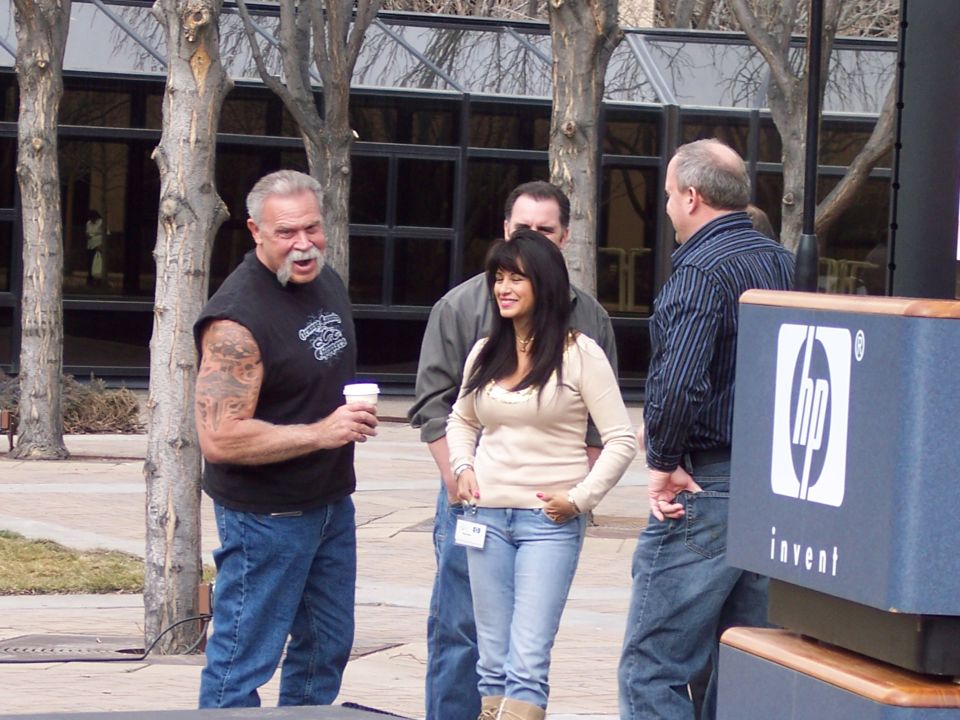 Group of people talking outdoors near an HP branded podium