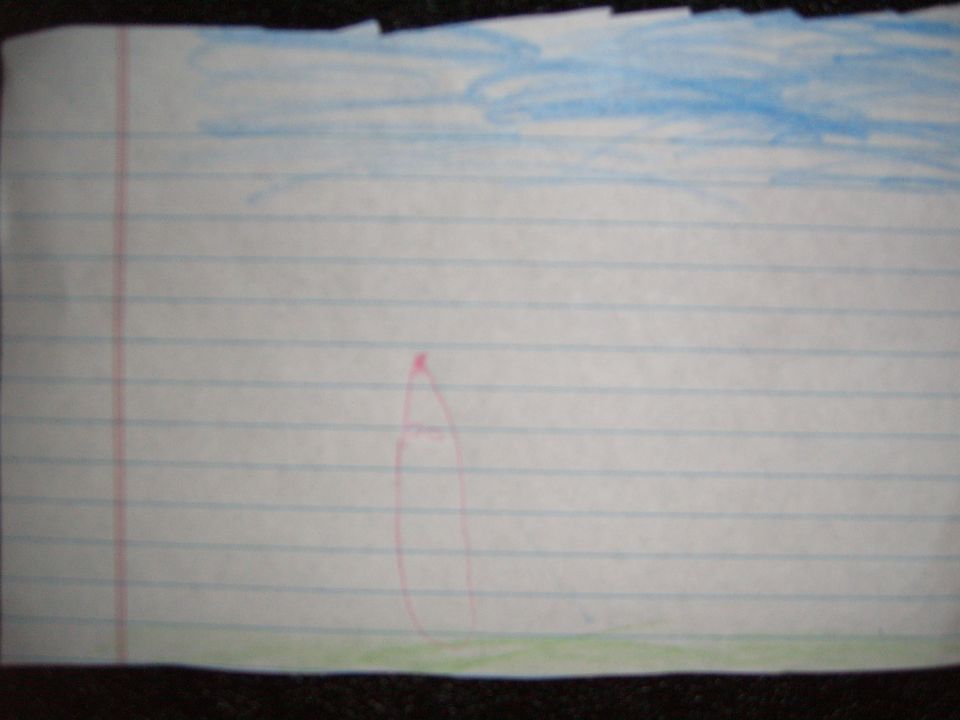Child's drawing of a red rocket ship against a blue sky on lined paper