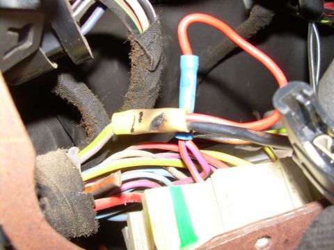 1988 Ford Bronco - A close-up view of a damaged electrical connector within a vehicle's wiring harness.
