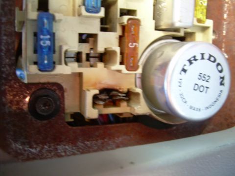 1988 Ford Bronco - Close-up of a vehicle's electrical fuse box, showing various fuses and a TRIDON 552 DOT component.