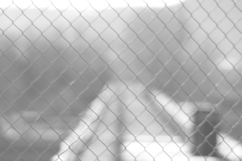 Blurry vehicle behind chain-link fence