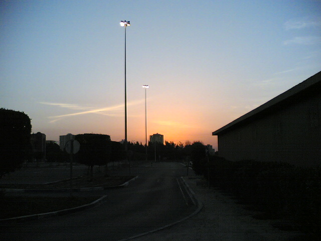 Street scene with tall light poles and buildings at sunset