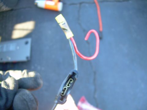 1988 Ford Bronco - A close-up shot focuses on automotive electrical wiring, including a fuse holder and a red wire.