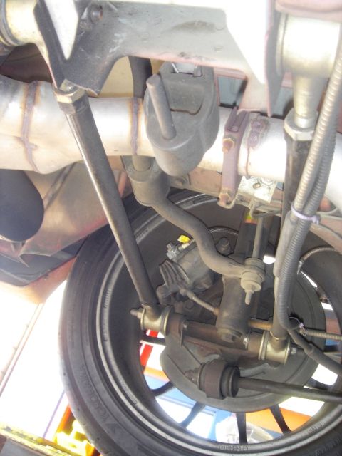 1991 Ford Taurus - Close-up of a vehicle's rear suspension and exhaust system, showing various mechanical parts.