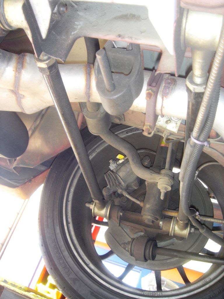 Underside view of car's rear suspension components and exhaust pipe