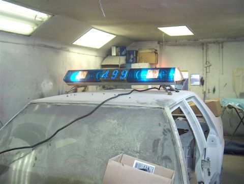 1990 Ford LTD Crown Victoria - Lightbar with digital display mounted on the roof of a vehicle undergoing work.