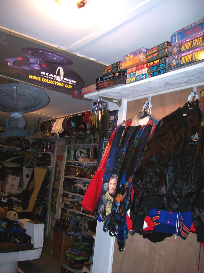 Star Trek memorabilia including puzzles, models, and jackets, with a large Enterprise model hanging from the ceiling