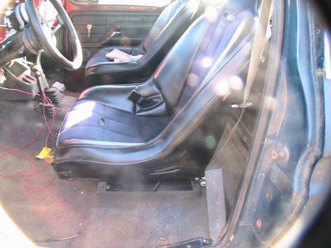 1977 Ford F-250 - The interior of a 1977 Ford F-250 shows its black bucket seats and manual gear shifter.