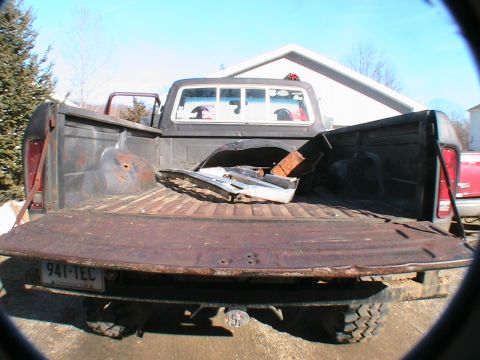 1977 Ford F-250 - Rear view of a 1977 Ford F-250 pickup truck bed, showing signs of wear and carrying some disassembled parts.