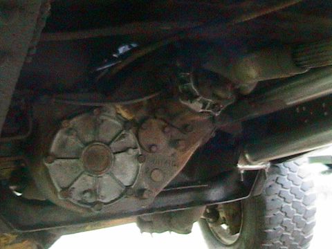 1977 Ford F-250 - Underside view of a truck's transfer case, a "SUPERMOTORS" watermark.