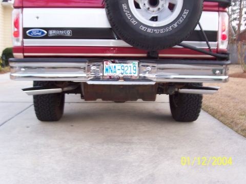 1994 Ford Bronco - The rear of a Ford Bronco shows its dual exhaust system and spare tire, with a license plate from 2004.