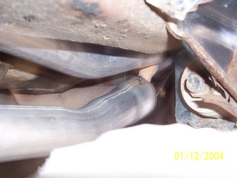 1994 Ford Bronco - Close-up view of a vehicle's exhaust system, showing the pipes and undercarriage components.