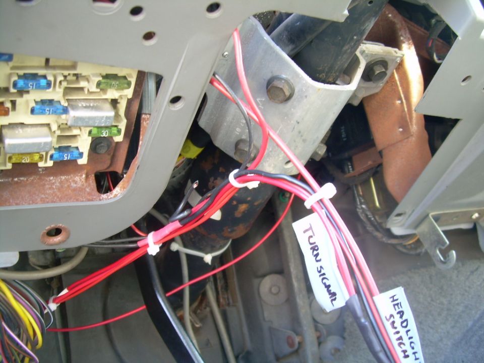 Close-up of a vehicle's interior fuse box and wiring harness with labels for 'TURN SIGNAL' and 'HEAD SW'