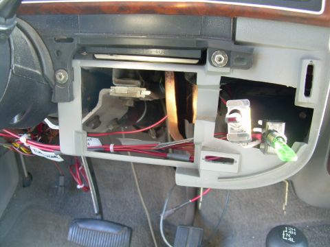 1988 Ford Bronco - Close-up of exposed dashboard wiring and aftermarket switches, with a green indicator light visible.