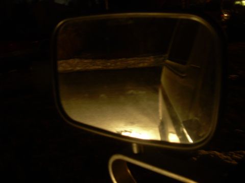1988 Ford Bronco - Reflection in the side mirror shows a dark road and the side of a vehicle, with a watermark at the bottom right.